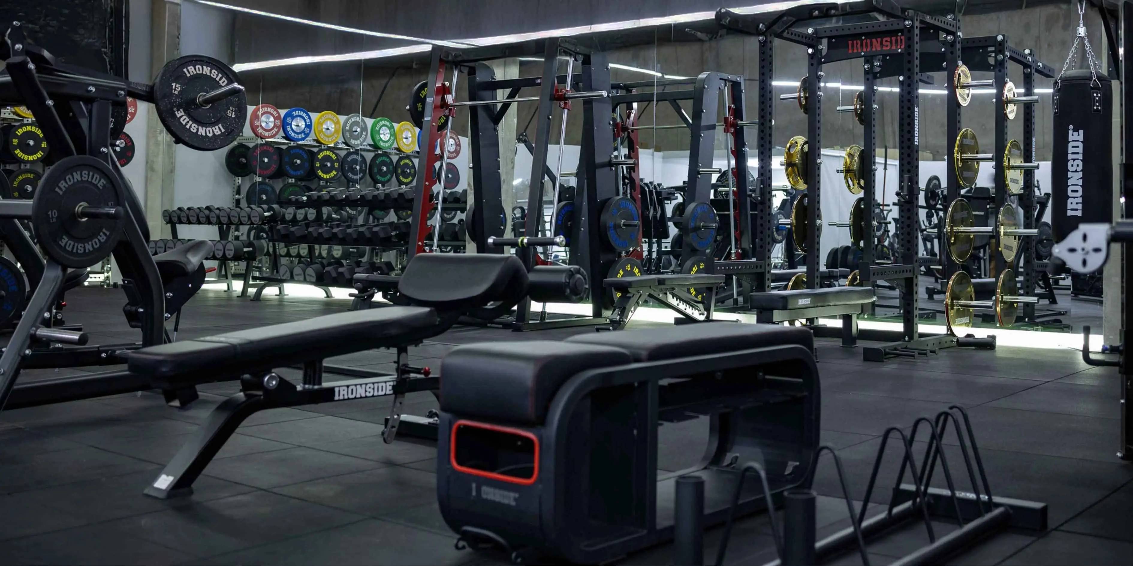 Sala de pesas con racks, discos y bancos